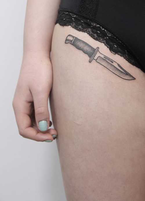 Маленькая татуировка ножа у девушки
