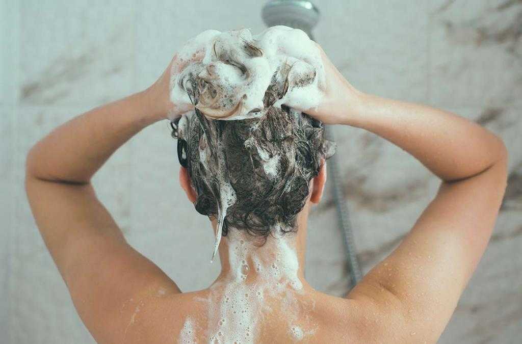 Девушка моет голову